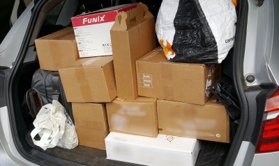 Un coffre ouvert avec plein de cartons de vin et quelques affaires de voyage