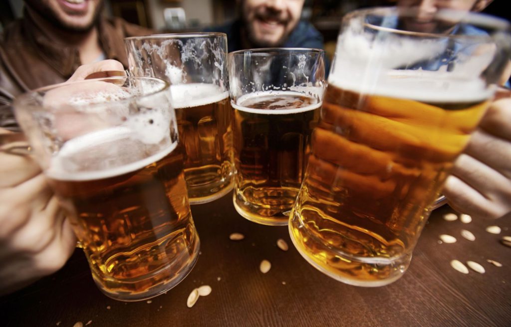 Trinquer entre amis ou collègues dans un bar avec des pintes de bière