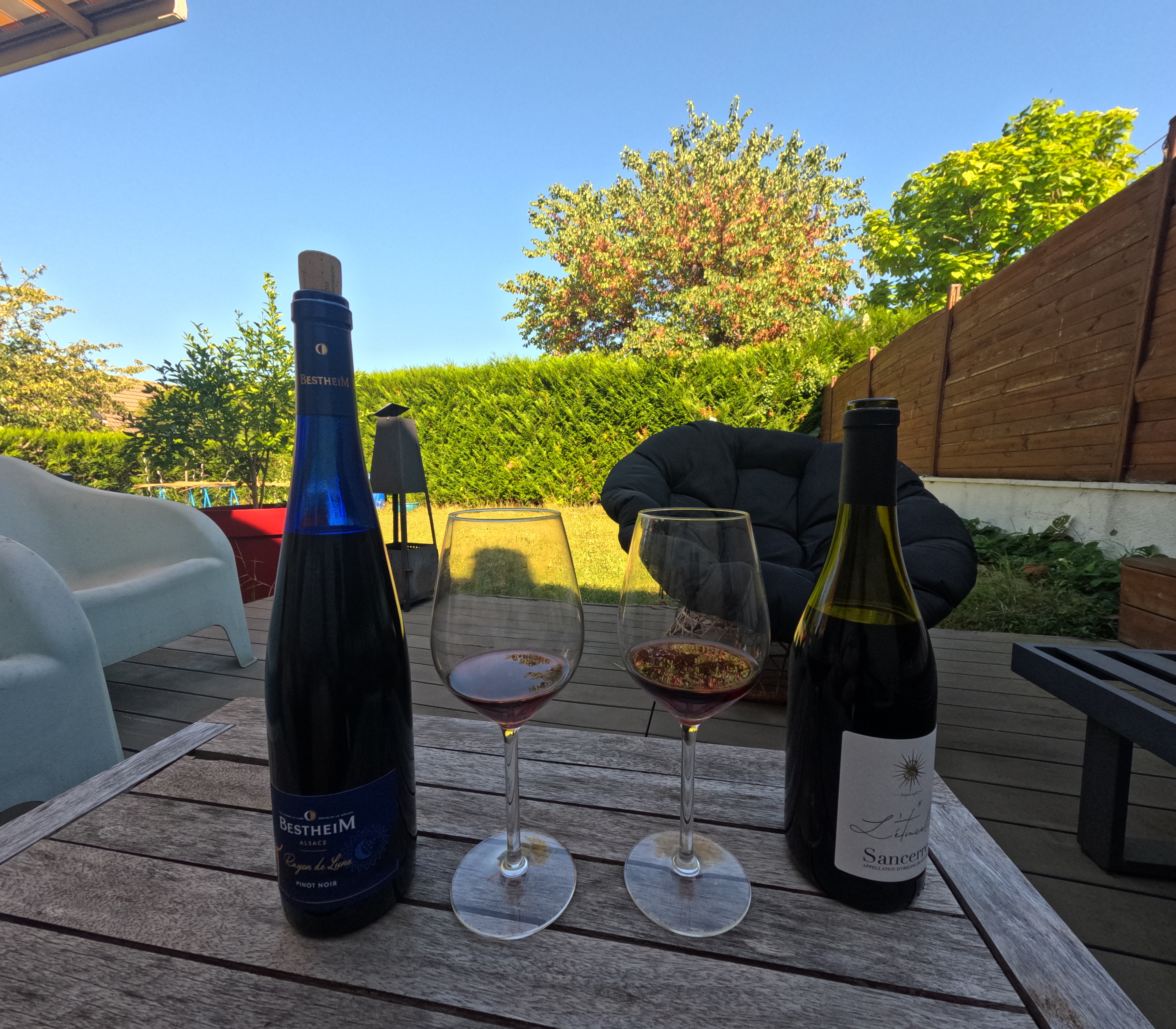 deux boutielle sur une table en bois en extérieur. une de Sancerre et une d'Alsace